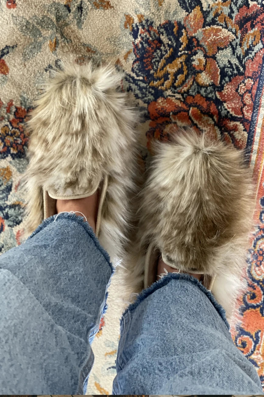 Chaussons en fausse fourrure sur tapis